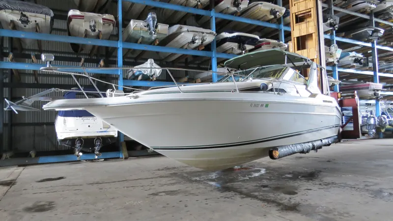 Slide: The Image of 1989 Sea Ray Sundancer 280 boat in storage, showcasing sleek design and white exterior. - 3