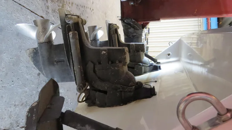 Slide: The Image of 1989 Sea Ray Sundancer 280 boat stern with dual propellers in a maintenance area. - 5