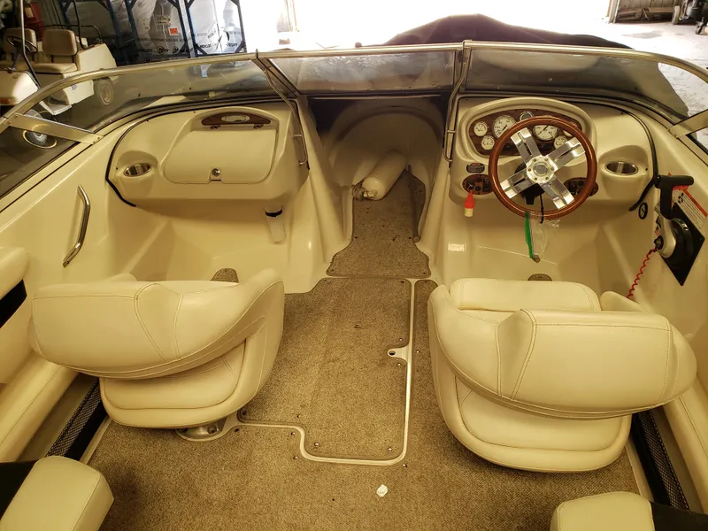 Slide: The Image of Interior of a 2010 Glastron/Carlson GT225BR boat with beige seating and dashboard. - 5