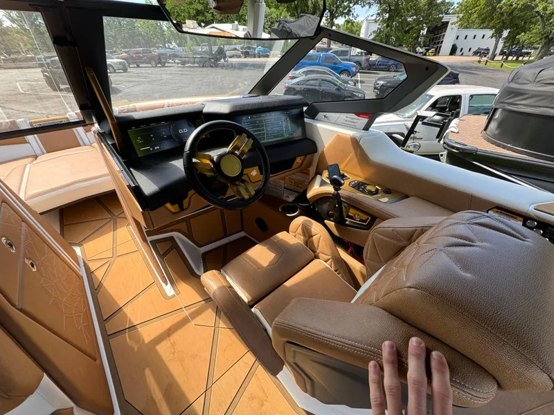 Slide: The Image of 2024 Nautique G25 Paragon cockpit with luxurious tan interior and advanced controls. - 13