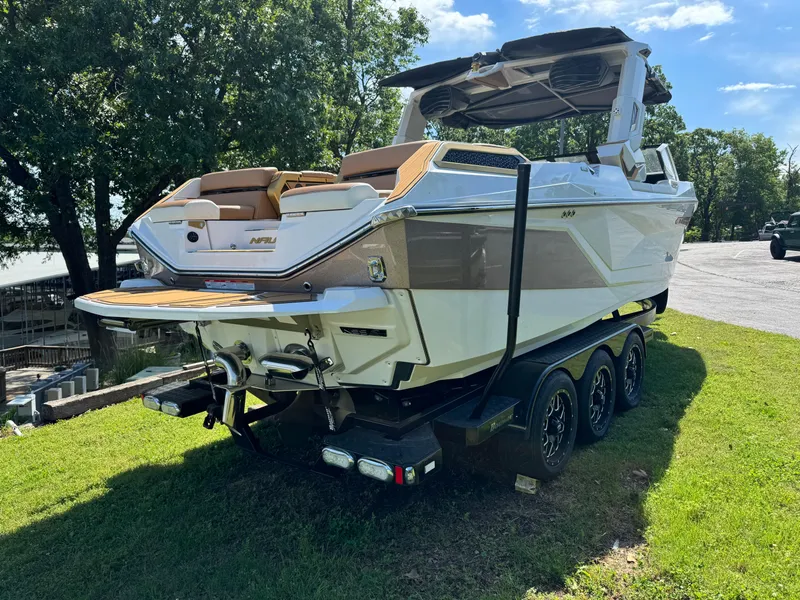 Slide: The Image of 2024 Nautique G25 Paragon boat on a trailer, parked on grass. - 4