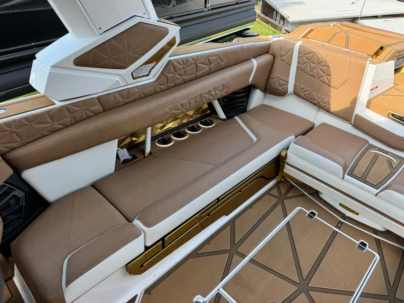 Slide: The Image of 2024 Nautique G25 Paragon interior with luxurious brown and white seating and cup holders. - 9