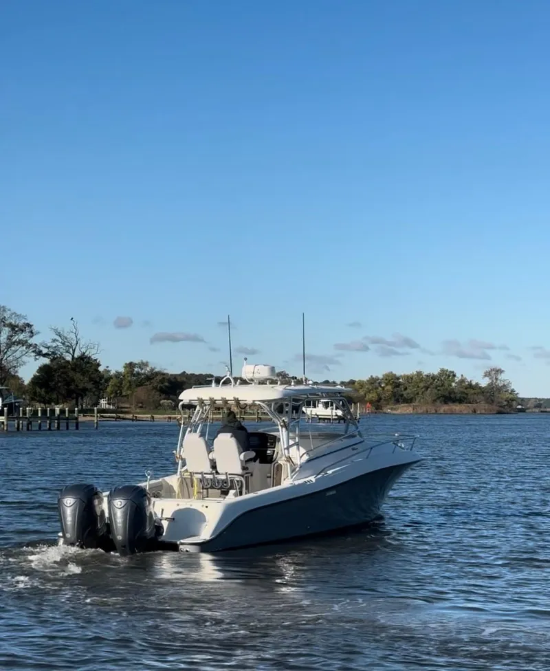 Slide: The Image of 2005 Hydra-Sports 33VX boat cruising on a calm river under a clear blue sky. - 1