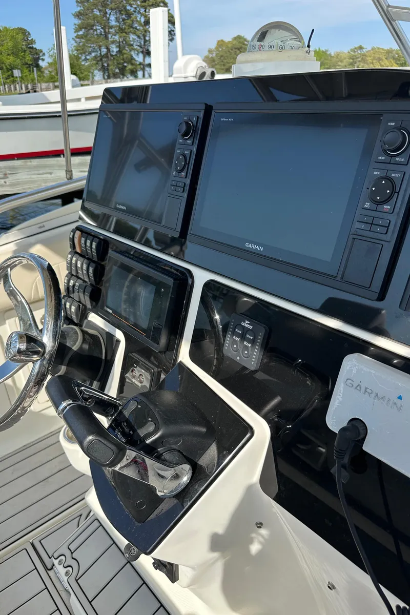 Slide: The Image of 2005 Hydra-Sports 33VX boat dashboard with Garmin navigation systems and steering wheel. - 2