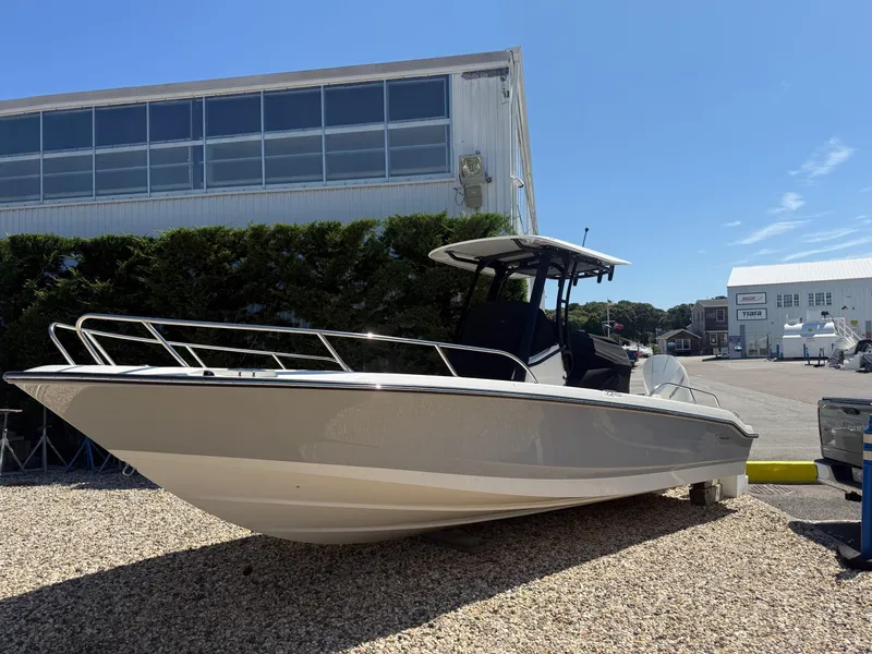 The Image of 2025 Boston Whaler 250 Dauntless boat displayed outdoors on gravel near a marina. - 0