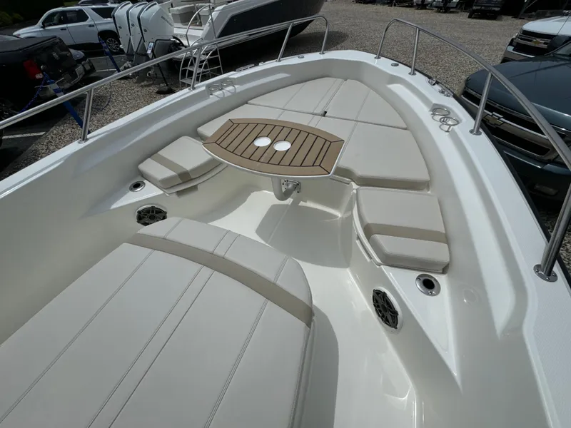 Slide: The Image of 2025 Boston Whaler 250 Dauntless boat interior with cushioned seating and wooden table. - 20