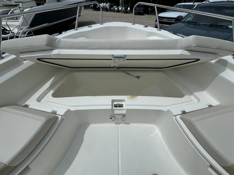 Slide: The Image of 2025 Boston Whaler 250 Dauntless boat with open storage compartment and cushioned seating. - 6