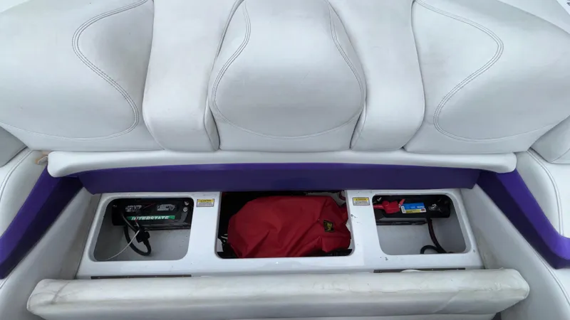 Slide: The Image of 2003 Baja 33 Outlaw boat seat storage compartments with red bag and accessories. - 12