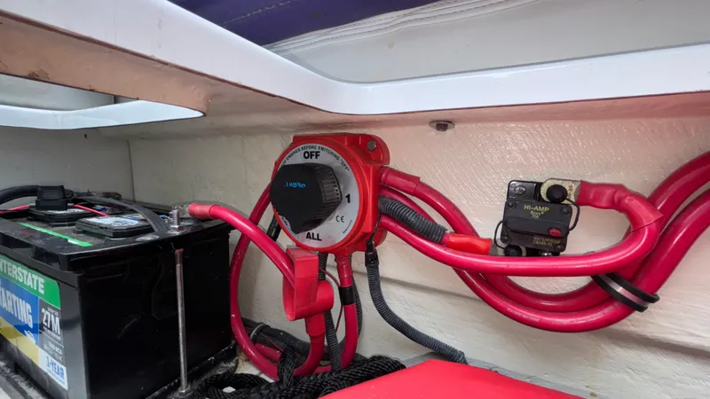 Slide: The Image of Battery compartment of a 2003 Baja 33 Outlaw boat with wiring and switch. - 13