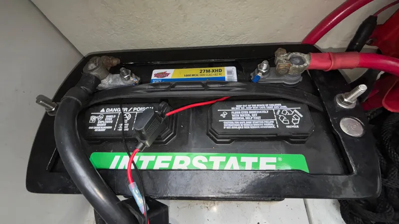 Slide: The Image of Interstate battery in a 2003 Baja 33 Outlaw boat, featuring connected cables. - 16