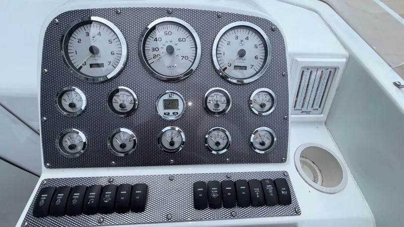 Slide: The Image of Dashboard of a 2003 Baja 33 Outlaw boat with gauges and switches. - 17