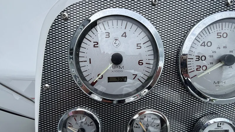 Slide: The Image of Dashboard of a 2003 Baja 33 Outlaw boat with RPM and speed gauges. - 18