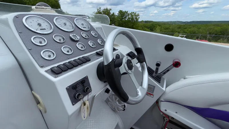 Slide: The Image of Cockpit of 2003 Baja 33 Outlaw boat with steering wheel and instrument panel. - 21