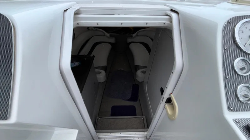 Slide: The Image of 2003 Baja 33 Outlaw boat interior cabin entrance with visible seating and dashboard gauges. - 22