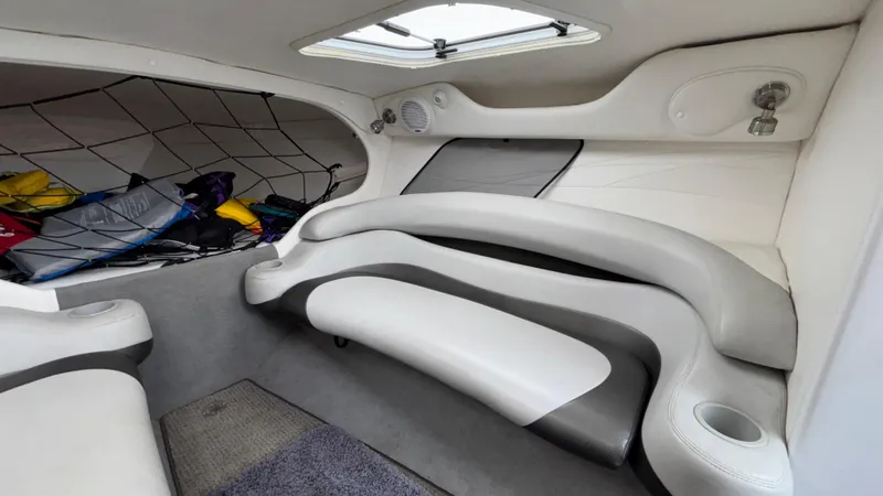 Slide: The Image of Interior of a 2003 Baja 33 Outlaw boat with white seating and storage net. - 24