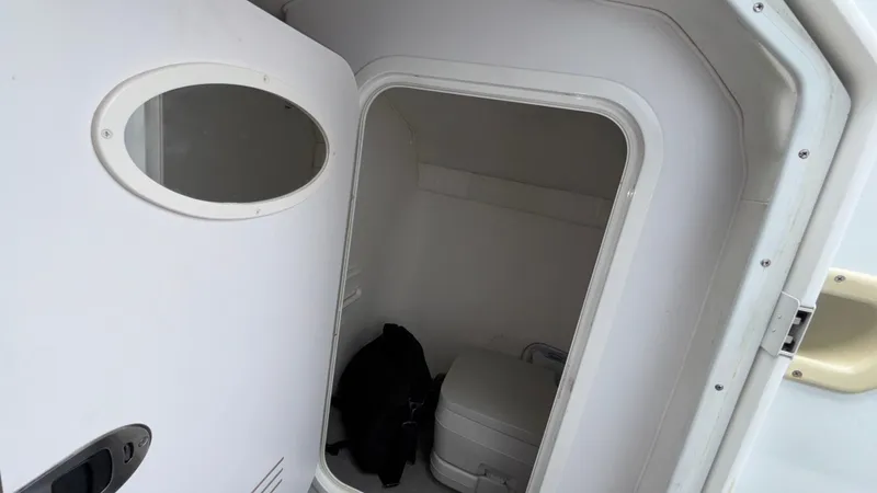 Slide: The Image of 2003 Baja 33 Outlaw boat interior with compact bathroom and toilet. - 30