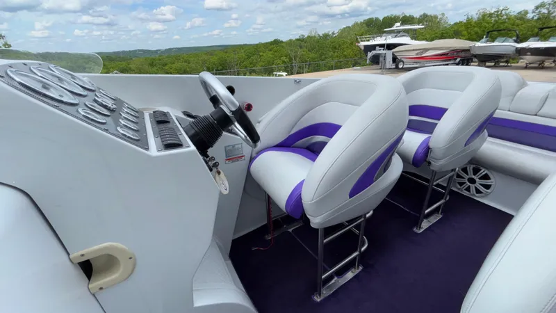 Slide: The Image of 2003 Baja 33 Outlaw boat interior with white and purple seating, steering wheel, and dashboard. - 34