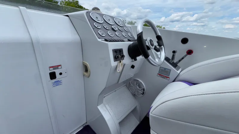 Slide: The Image of 2003 Baja 33 Outlaw boat cockpit with white steering wheel and control panel. - 35