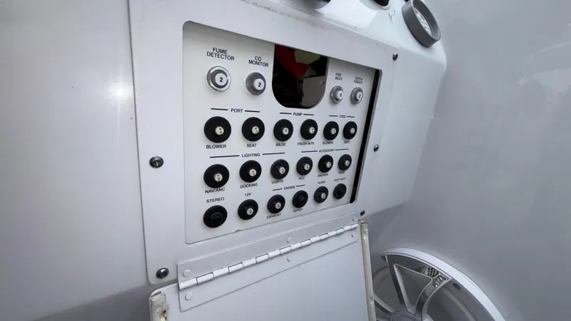 Slide: The Image of Control panel of a 2003 Baja 33 Outlaw boat with various switches and indicators. - 38