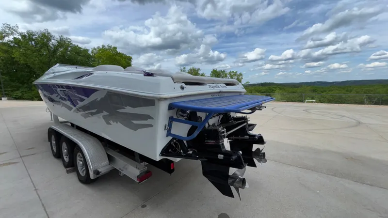 Slide: The Image of 2003 Baja 33 Outlaw boat on trailer, parked outdoors under a cloudy sky. - 39