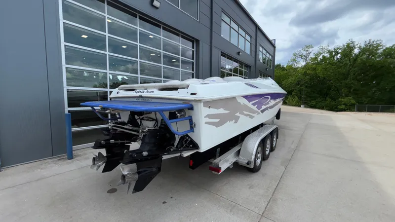 Slide: The Image of 2003 Baja 33 Outlaw boat on trailer near modern building. - 41
