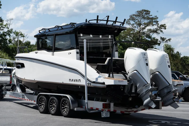 The Image of 2025 Navan C30 boat on trailer with dual outboard motors, parked outdoors. - 0