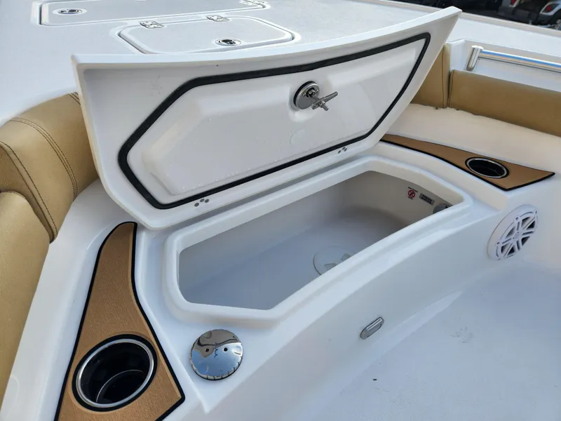 Slide: The Image of 2025 Sportsman Masters 247OE Bay Boat storage compartment with cup holders and speaker. - 10