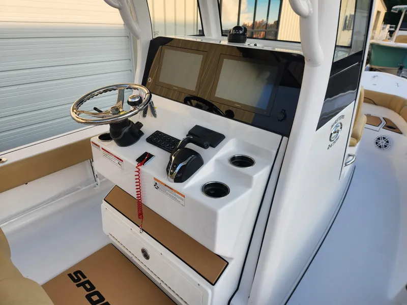 Slide: The Image of 2025 Sportsman Masters 247OE Bay Boat helm with steering wheel and control panel. - 14