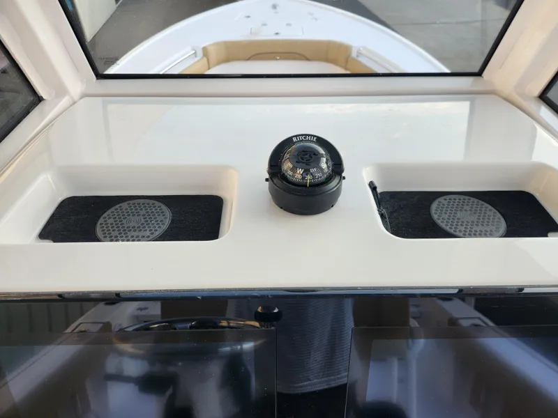 Slide: The Image of Dashboard of 2025 Sportsman Masters 247OE Bay Boat with compass and storage compartments. - 16