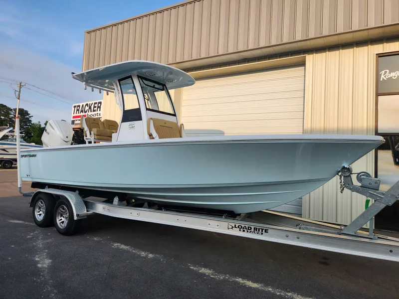 Slide: The Image of 2025 Sportsman Masters 247OE Bay Boat on trailer, parked outside a building. - 2