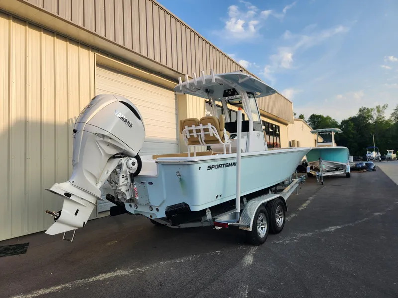 Slide: The Image of 2025 Sportsman Masters 247OE Bay Boat on trailer, parked outside a building. - 4