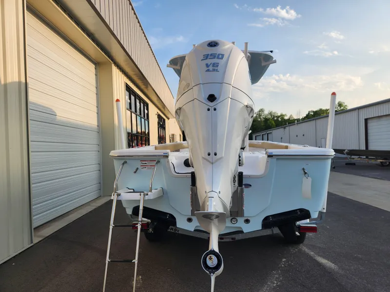 Slide: The Image of 2025 Sportsman Masters 247OE Bay Boat with 350 V6 engine, docked near warehouse. - 5