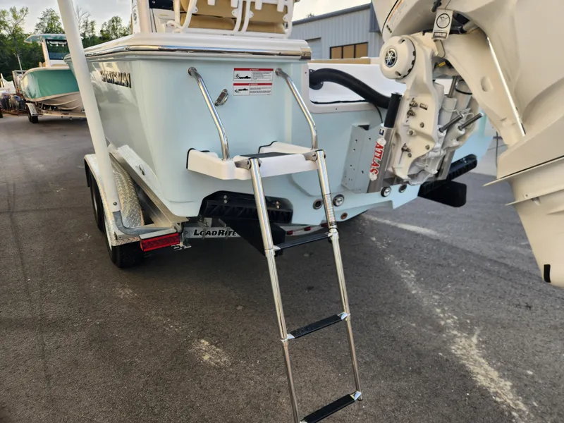 Slide: The Image of 2025 Sportsman Masters 247OE Bay Boat on trailer with ladder and outboard motor. - 6