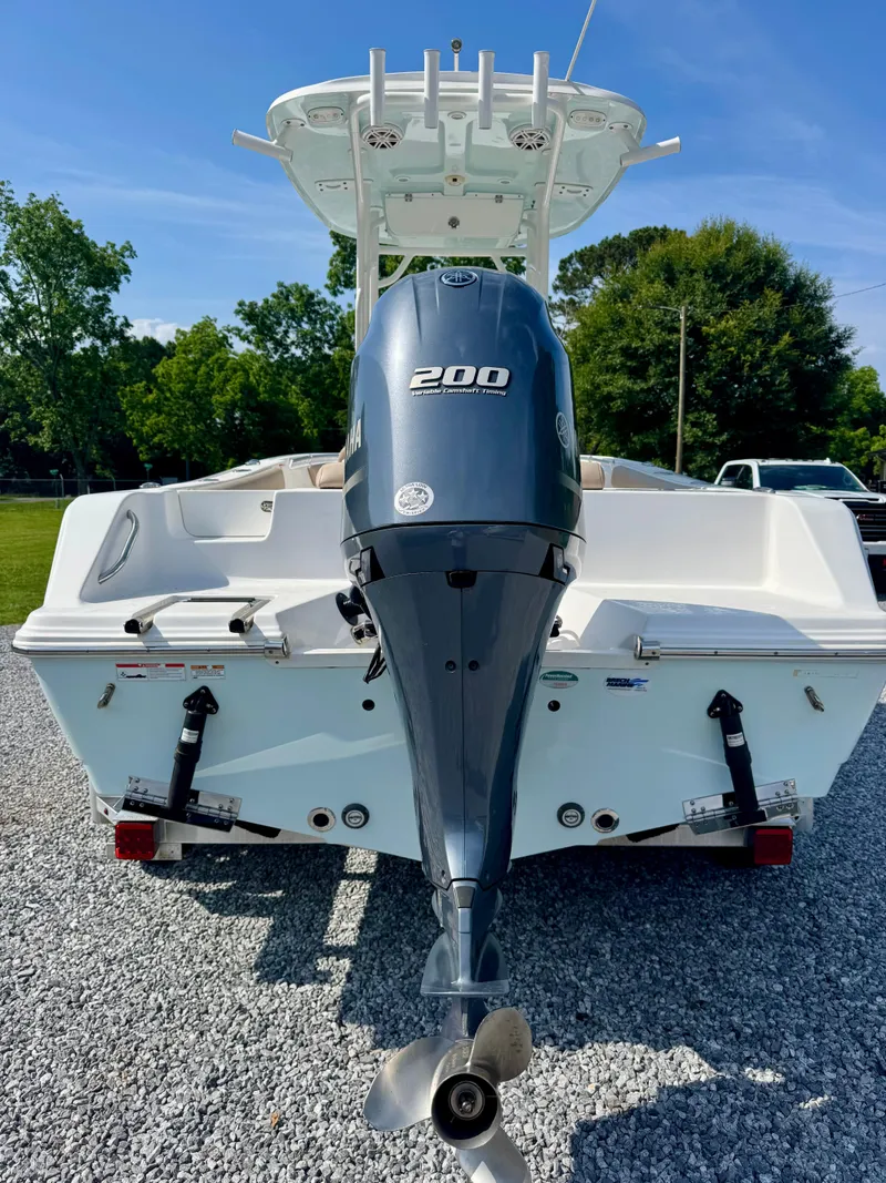 Slide: The Image of 2020 Sportsman Open 212 Center Console boat with powerful 200 engine, parked on gravel. - 5