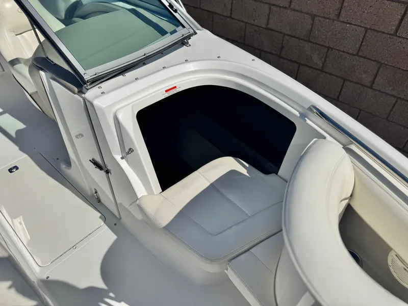 Slide: The Image of 2006 Cobalt 232 boat interior with white seating and storage compartment. - 18