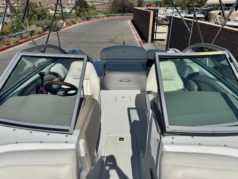 Slide: The Image of 2006 Cobalt 232 boat interior with dual windshields and seating, parked on a paved road. - 19