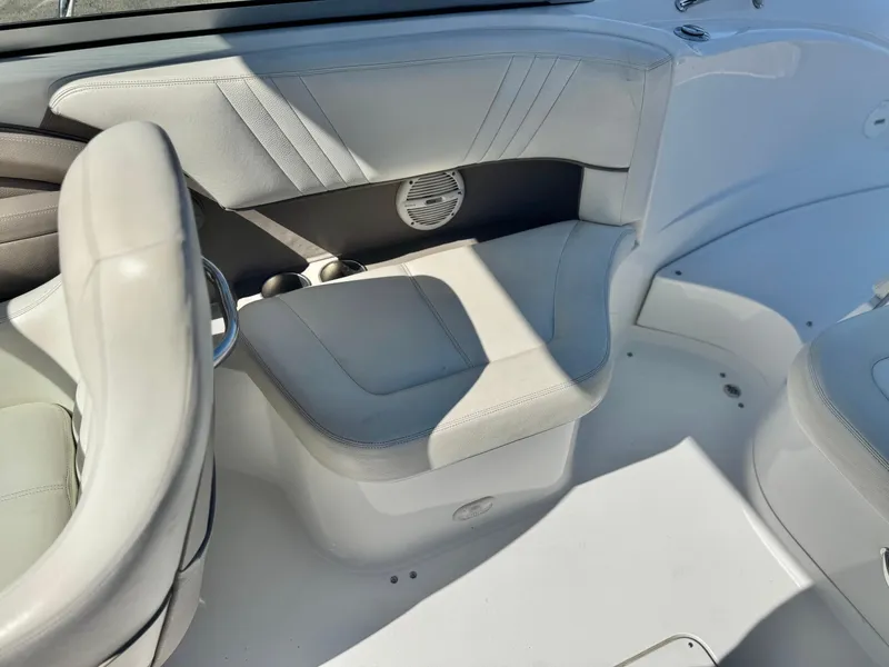 Slide: The Image of Interior seating of a 2006 Cobalt 232 boat, featuring white upholstery and built-in speaker. - 21