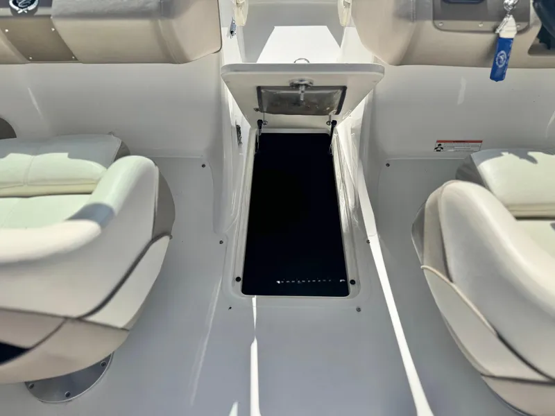 Slide: The Image of 2006 Cobalt 232 boat interior with open storage compartment between seats. - 25