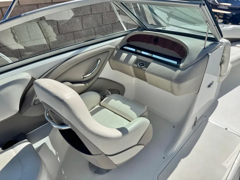 Slide: The Image of Interior of a 2006 Cobalt 232 boat, featuring a sleek helm and comfortable seating. - 26