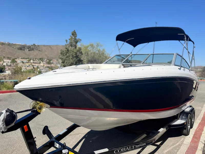 Slide: The Image of 2006 Cobalt 232 boat on trailer, blue and white, with canopy, parked outdoors. - 3