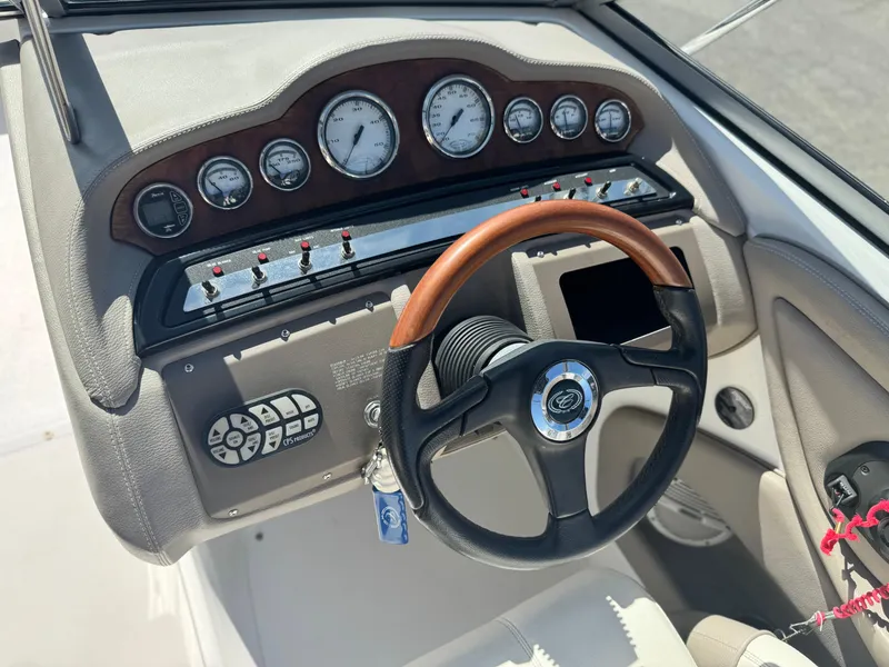 Slide: The Image of 2006 Cobalt 232 boat dashboard with gauges and wood-accented steering wheel. - 31