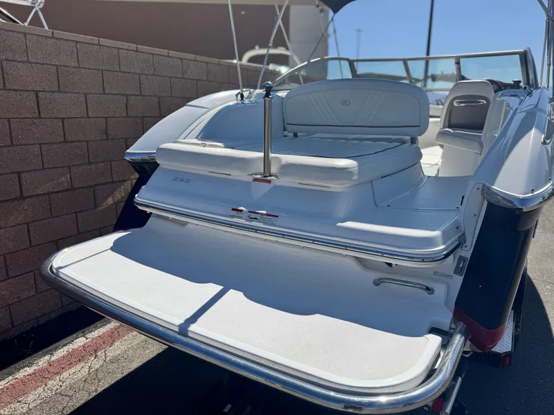 Slide: The Image of 2006 Cobalt 232 boat with white seating and swim platform, parked outdoors. - 6