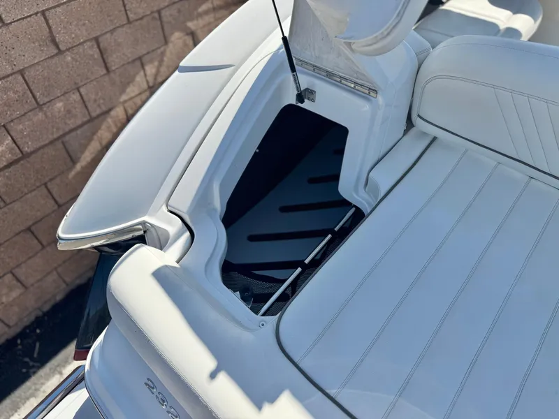 Slide: The Image of 2006 Cobalt 232 boat with open storage compartment, featuring white seating and sleek design. - 9