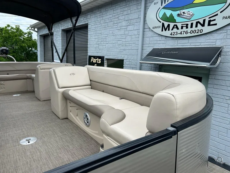 Slide: The Image of 2018 Avalon 2485 LSZ Cruise pontoon boat with beige seating and marine dealership backdrop. - 6