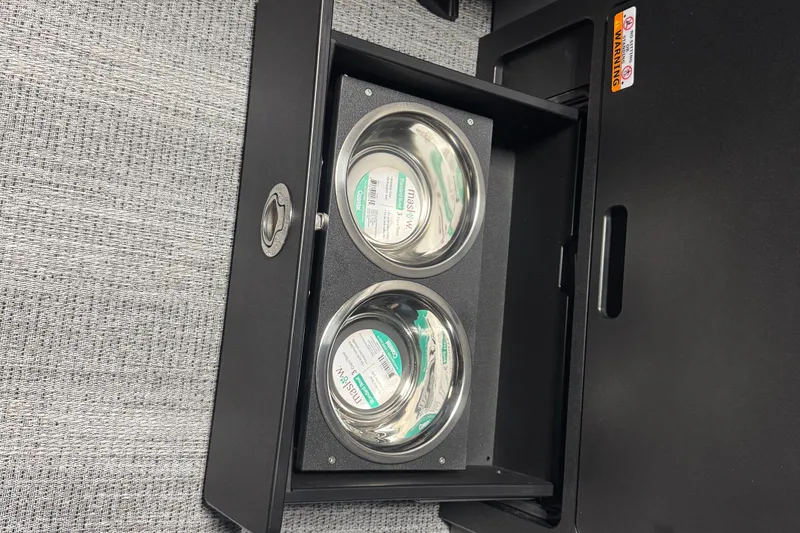 Slide: The Image of Open storage compartment with two stainless steel bowls on a Bennington 24 MSB, 2026 model. - 13