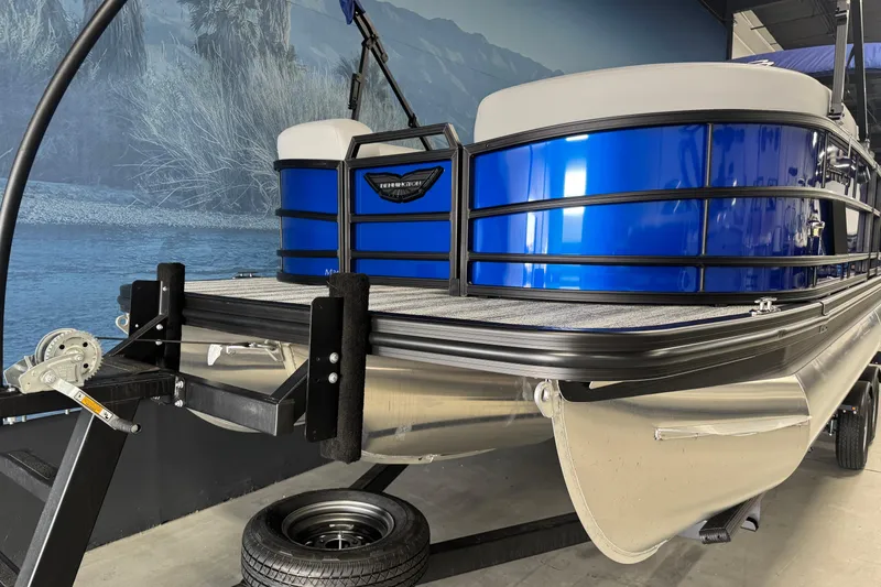 Slide: The Image of 2026 Bennington 24 MSB pontoon boat with blue exterior on trailer. - 2