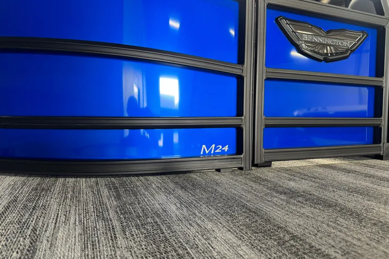 Slide: The Image of 2026 Bennington 24 MSB pontoon boat with sleek blue paneling and logo detail. - 3