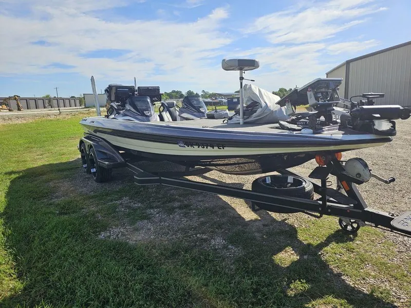 Slide: The Image of 2020 Skeeter FXR21 bass boat on trailer, parked outdoors under a clear sky. - 12