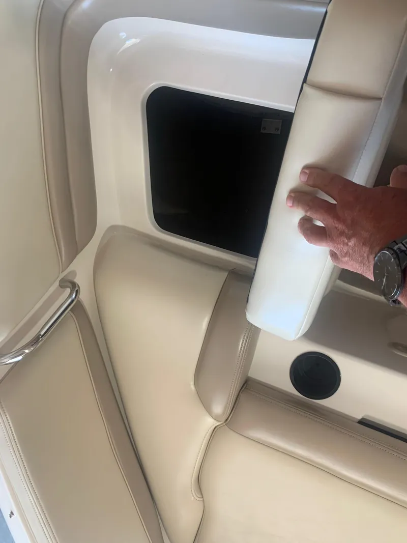 Slide: The Image of 2003 Bryant 232 RB boat interior with storage compartment and beige seating. - 16