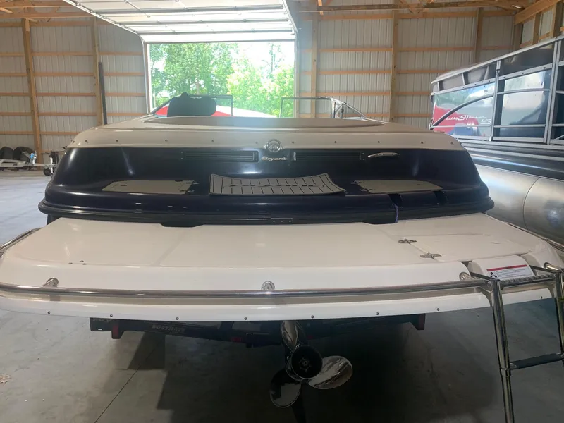 Slide: The Image of 2003 Bryant 232 RB boat in a garage, rear view with open door. - 2